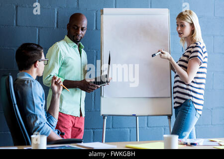 Colleagues standing by white board Stock Photo