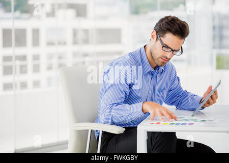 Businessman looking at document and using digital tablet Stock Photo