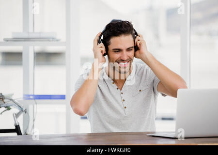 Young man using headphones and laptop Stock Photo