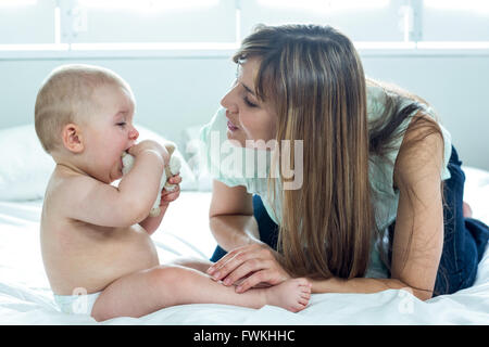 Woman playing with baby boy on bed Stock Photo