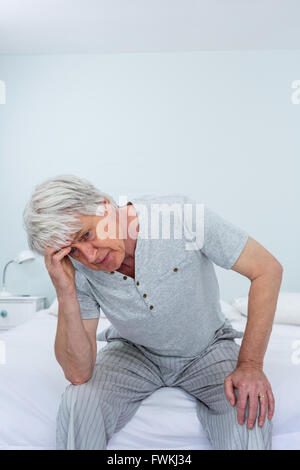 Senior man suffering from headache while sitting at home Stock Photo