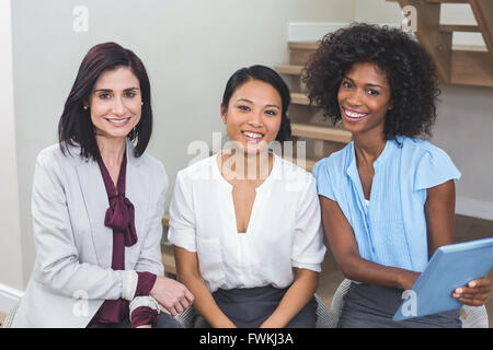 Female business colleagues discussing on digital tablet Stock Photo