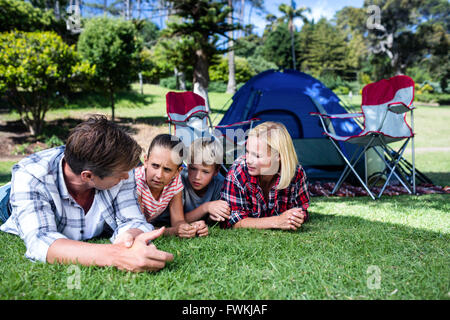 Family talking to each other while lying on grass Stock Photo