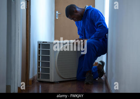 Handyman testing air conditioner Stock Photo