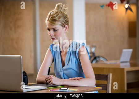 Graphic designer drawing on a graphic tablet while using laptop Stock Photo