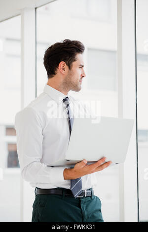 Businessman using laptop and taking notes Stock Photo