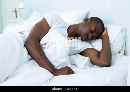 Young man lying on bed Stock Photo
