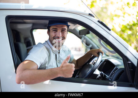 Cheerful delivery man showing thumbs up Stock Photo