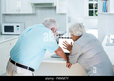 Rear view of senior couple using laptop Stock Photo