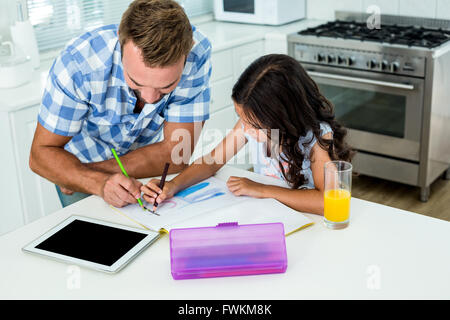 Father assisting daughter in doing homework Stock Photo