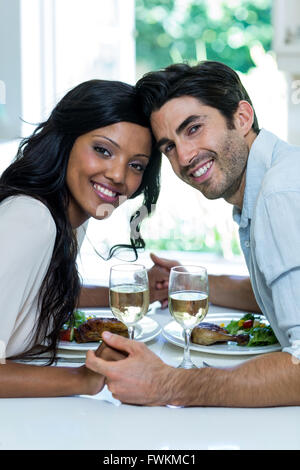 Portrait of couple holding hands while having meal Stock Photo