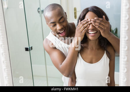Reflection of young man covering womans eyes Stock Photo