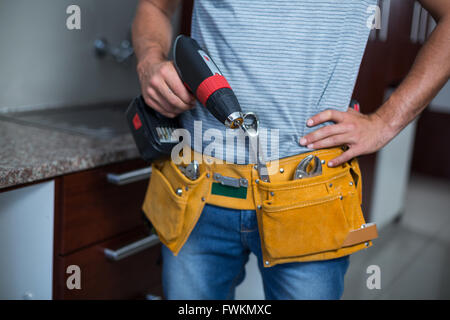 Midsection of man holding cordless hand drill Stock Photo