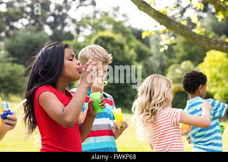 Children blowing bubbles wand in the park Stock Photo