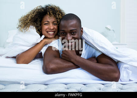 Portrait of happy couple embracing each other on bed Stock Photo