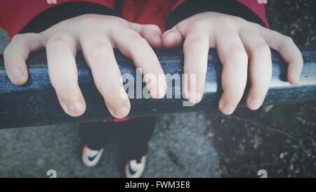 Close-Up Of Boy Hands On Railing