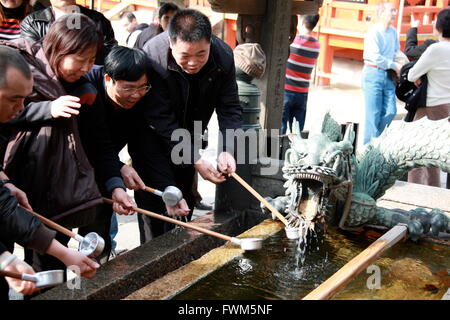 Tourists around a dragon water fountain at Kiyomizu-dera temple, Kyoto, Japan Stock Photo