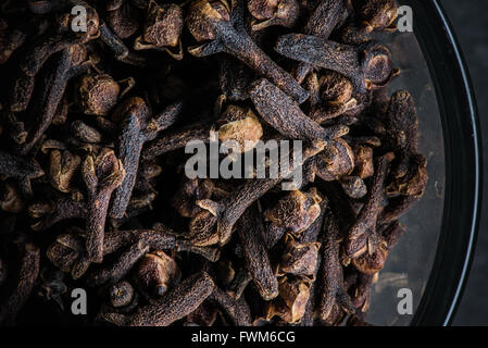 Glass bowl of cloves close up over a slate background Stock Photo