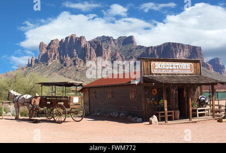 Old Wild West Cowboy town with horse drawn carriage and mountains in background Stock Photo