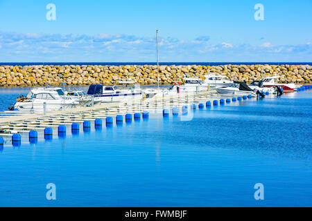 Simrishamn, Sweden - April 1, 2016: Boats at the marina on a very fine spring day with sunshine and hardly any wind. Some distan Stock Photo