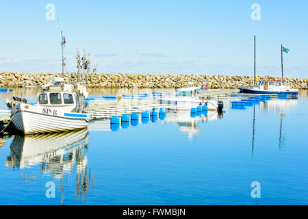 Simrishamn, Sweden - April 1, 2016: Boats at the marina on a very fine spring day with sunshine and hardly any wind. Some distan Stock Photo