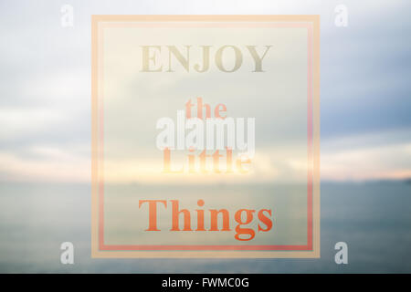 Inspirational quote of enjoy the little things on blue sea background Stock Photo
