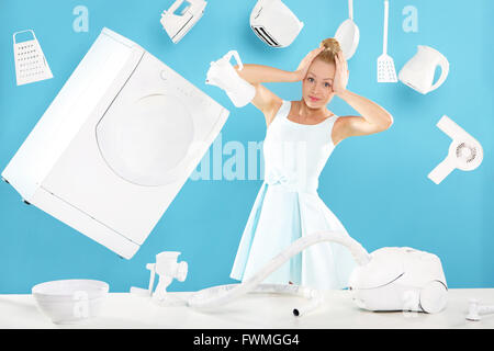 Young housewife overwhelmed by tasks associated with running a home. Joyful woman does housework. Stock Photo