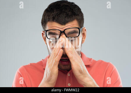 tired man in eyeglasses rubbing eyes Stock Photo