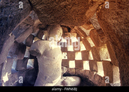 A Buddha statue inside a Borobudur stupa Stock Photo