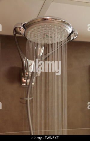 A large spray shower head with running water in a hotel bathroom in the Netherlands.. Stock Photo