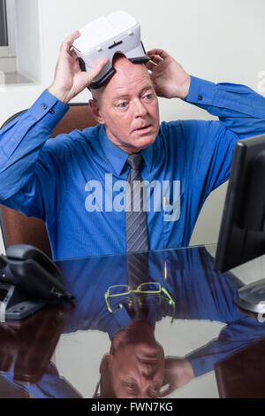 Corporate executive putting on virtual reality headset Stock Photo
