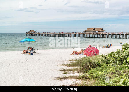 People on beach and pier in the city of Naples on the west coast of Florida, USA Stock Photo