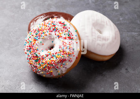 Colorful donuts on stone table Stock Photo