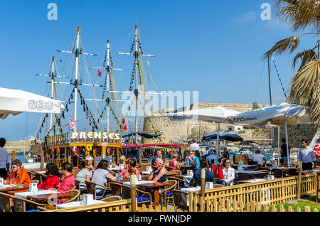 Tourists dining al fresco outside a restaurant near the castle in Kyrenia, Northern Cyprus. Stock Photo