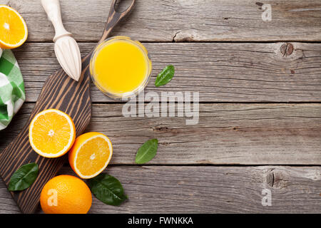 Oranges and juice glass on wooden table. Top view with copy space Stock Photo