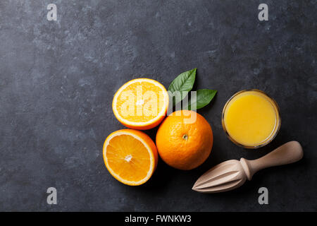 Oranges and juice glass on stone background. Top view with copy space Stock Photo