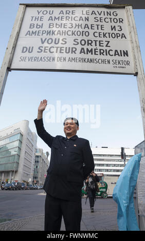 Berlin, Germany. 6th April 2016. Kim Jong Un impersonator, Howard X from Hong Kong, visited Berlin, touring the major tourist sites to the surprise of tourists and locals. Howard was visiting Germany to film an advertisement for the popular German TV show 'Schlag den Star' with comedian Elton.  Here, at Checkpoint Charlie, leaving the 'American Sector' Credit:  Julie Woodhouse/Alamy Live News. Model release available for Howard X Stock Photo