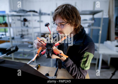 Development engineer for drones, Gerd Jacobs, holds a race copter, a highspeed drone) in his hands at the workshop of Cooper Copter, a company specialising in the manufacture of civilian drones, in Hamburg, Germany, 6 April 2016. The company hosted a conference on 'Drones: Technology, hype and risks'. Photo: Axel Heimken/dpa Stock Photo