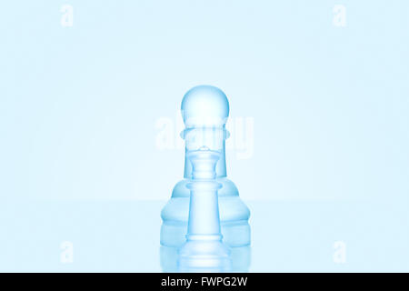 Chess game concept of a single icy frosted pawn standing alone on glacial chessboard. Stock Photo