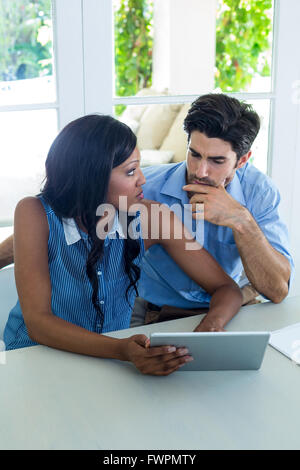 Worried couple using digital tablet Stock Photo