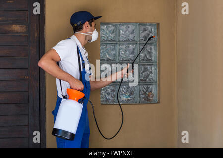 Worker spraying chemical on window Stock Photo