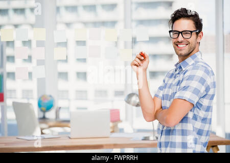 Portrait of businessman writing on sticky notes in office Stock Photo