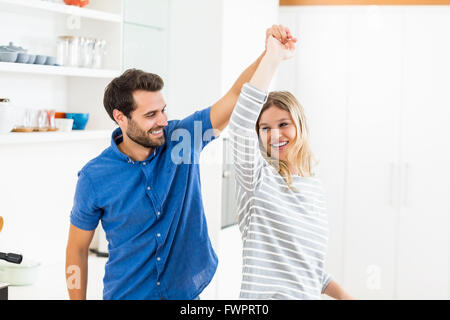 Happy couple dancing in kitchen Stock Photo