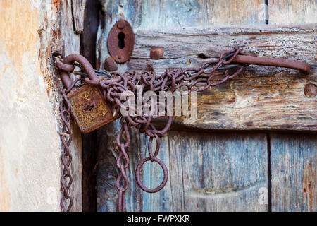Rusty door lock and chain on an old door Stock Photo