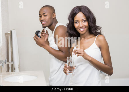 Portrait of beautiful woman putting pill in to a glass of water Stock Photo