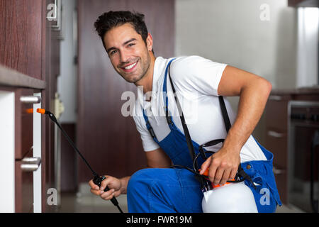 Portrait of confident pesticide worker crouching Stock Photo