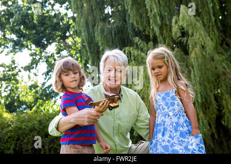 Grandfather with grandchildren at back yard Stock Photo