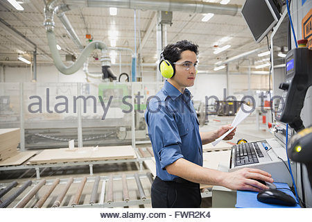 Worker using computer in factory that specialises in creating ...