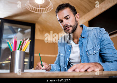 Man in office writing in a notepad Stock Photo