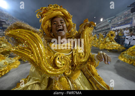 Woman in brazilian samba carnival costume with colorful feathers plumage  with mobile phone take selfie in old entrance with big window Stock Photo